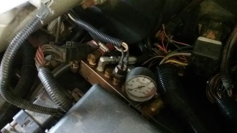1995 Ford Bronco - A close-up view of a brass manifold with a pressure gauge and several pneumatic fittings, likely part of an air suspension or accessory sys…