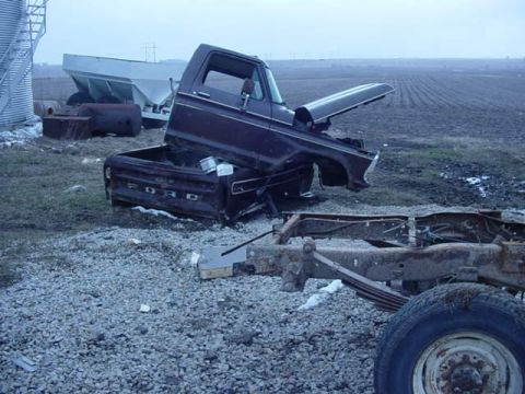 1992 Ford Bronco - A disassembled Ford truck sits in a field with a silo and agricultural equipment in the background.