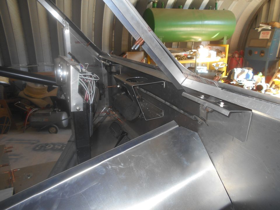 Close-up of vehicle interior with metal framing, wiring, and a motor.