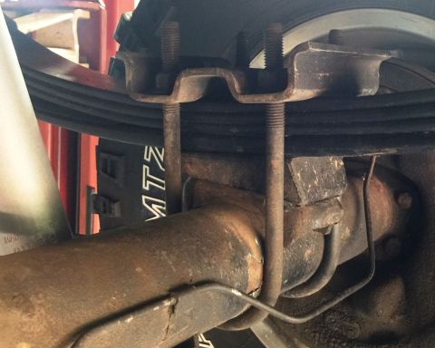1994 Ford Bronco - This close-up photo shows the underside of a vehicle's rear axle assembly, focusing on the U-bolts and leaf springs that attach to the axle…