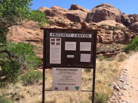 1984 Ford Bronco - A sign for Pritchett Canyon is visible in front of a rocky landscape. The sign provides information about the canyon, including its difficu…