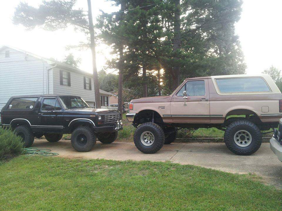 Two lifted Ford Broncos parked side-by-side.