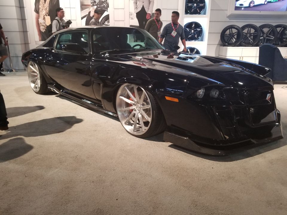 Black pickup truck with custom wheels, lowered suspension