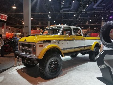1969 Pontiac Firebird - A yellow pickup truck with a lifted suspension and racing stripes is on display.