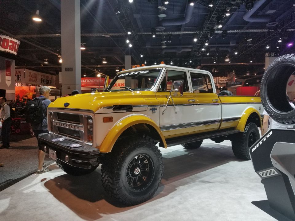 yellow pickup truck with lifted suspension and racing stripes