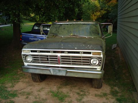 1967 Ford F-250 - A 1973 Ford F-Series truck is parked next to a building, with another truck visible in the background.
