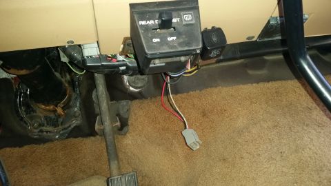 1985 Ford Bronco - This is an interior shot of a 1985 Ford Bronco, showing the driver's side footwell and dashboard area. Visible components include the steer…