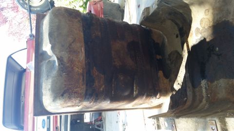 1985 Ford Bronco - A heavily rusted and dirty fuel tank is shown removed from a vehicle, likely a truck or SUV. The tank appears to be made of metal and has a…