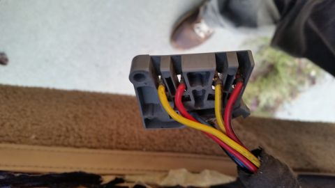 1985 Ford Bronco - A close-up view shows a grey plastic electrical connector with three wires: yellow, red, and black. The wires are connected to metal termin…