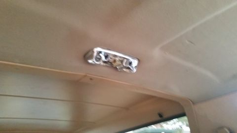 1985 Ford Bronco - An interior shot shows the headliner of a vehicle with a chrome dome light fixture. The headliner is a light tan color and appears to be sl…