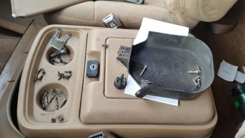 1985 Ford Bronco - Interior view of a dashboard with several gauges and some clutter.