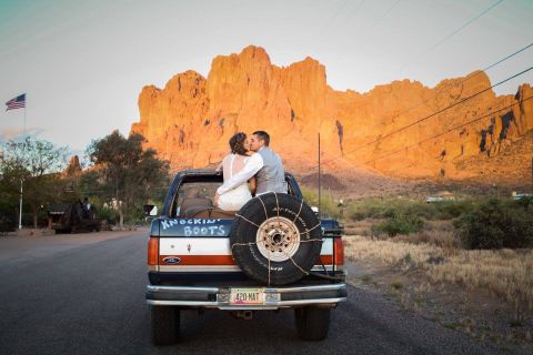 1988 Ford Bronco - Couple shares a kiss in the back of a Ford pickup truck with a desert mountain backdrop.