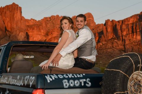 1988 Ford Bronco - A newly married couple poses in the back of a decorated pickup truck with a desert mountain backdrop.