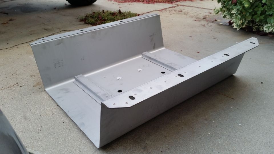 Aluminum fuel tank assembly with mounting holes, resting on concrete