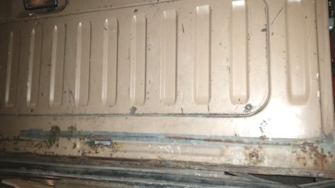 1985 Ford Bronco - Tailgate panel detail with vertical ribs, showing signs of rust. Likely from a 1980s Ford Bronco.