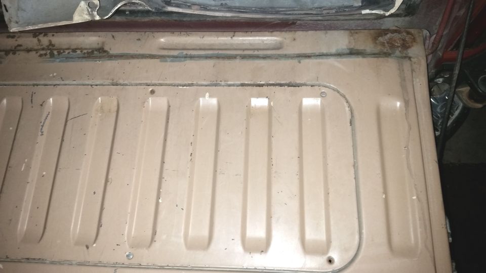 tan ribbed panel in vehicle cargo area with some rust spots