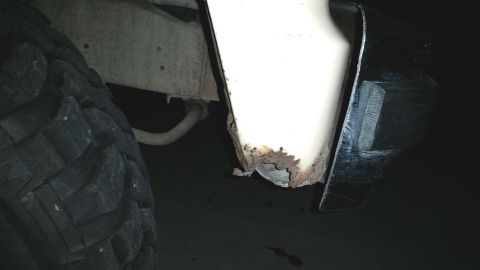 1985 Ford Bronco - The lower body panel shows significant rust damage, with a large off-road tire visible.