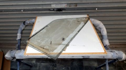 1962 MG B - A car door window assembly, likely for a classic vehicle, is shown resting on a support structure.