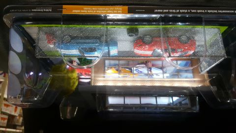 1973 Ford Mustang - Toy cars are displayed in packaging, with a background that resembles a showroom.