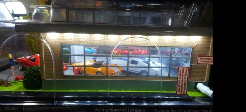 1973 Ford Mustang - This diorama depicts a miniature dealership scene with several model cars displayed inside.