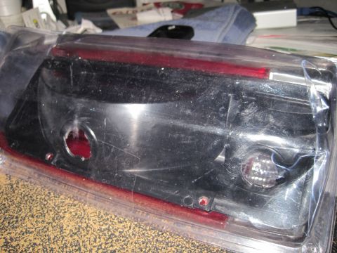 1989 Ford Bronco - This is a smoked taillight assembly, likely a replacement part, shown in its original packaging.