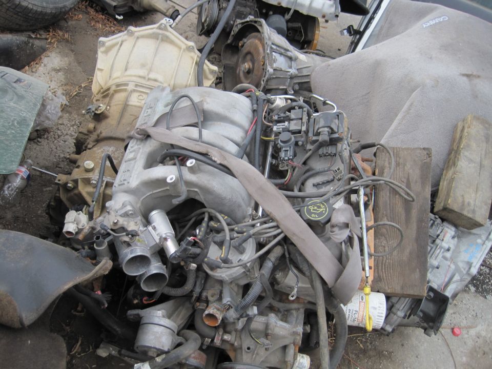 Engine and transmission assembly with fuel injection system and belts