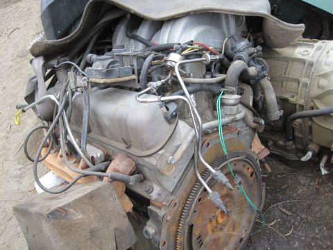 1989 Ford Bronco - This V8 engine and transmission assembly is shown outside, supported by wooden blocks.