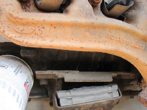 1989 Ford Bronco - Close-up of a rusty engine component, likely a Ford part, with an oil filter attached. Part number E9TE 9431 CA is visible.