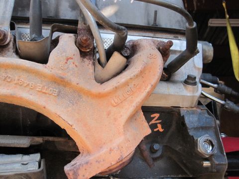 1989 Ford Bronco - Rusty exhaust manifold shows '88' casting and part number 'E0TE 9483 CA'.