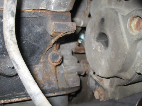 1989 Ford Bronco - A rusty engine bracket is visible next to an alternator in this close-up engine view.