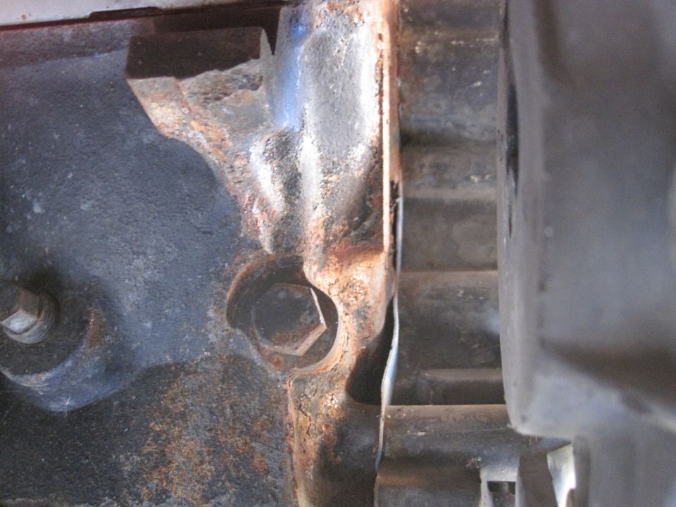 Close-up of rusty engine block casting with bolt