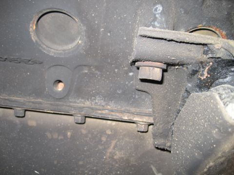1989 Ford Bronco - This is a close-up view of a heavily soiled engine block, showing a bolt and mounting bracket.