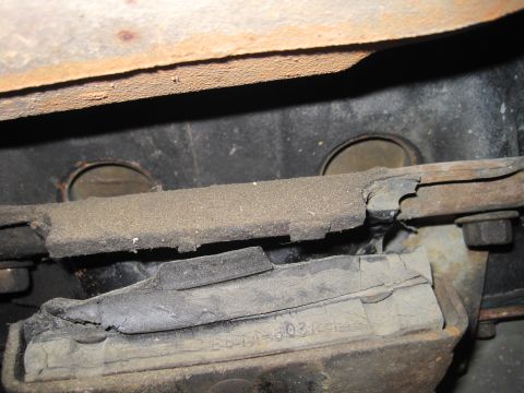 1989 Ford Bronco - Close-up of a worn engine mount, showing signs of damage and a partial part number.