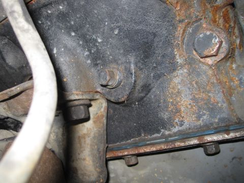 1989 Ford Bronco - Detail of an engine block, showing bolts and significant rust.