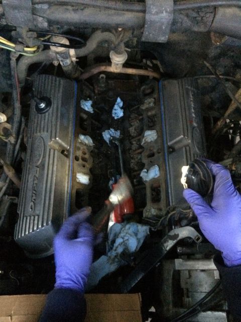 1989 Ford Bronco - Close-up of engine components, including Ford Racing valve covers, during a reassembly process.