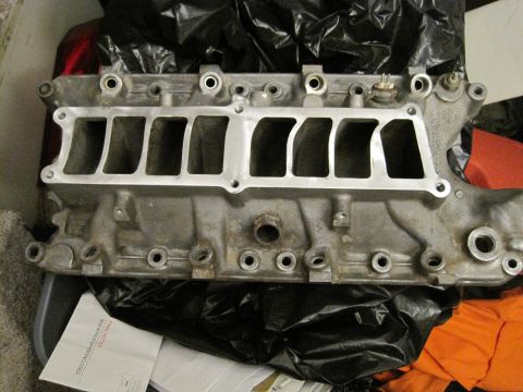 1989 Ford Bronco - A close-up view of an engine intake manifold, likely during a reassembly process.