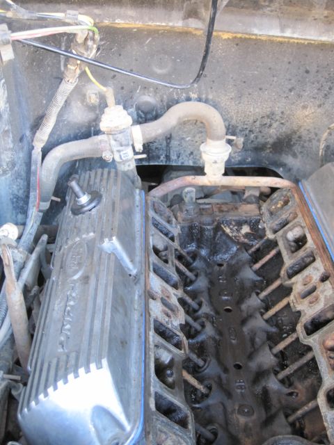 1989 Ford Bronco - Close-up of an engine valve cover, possibly from a Ford vehicle, during reassembly.