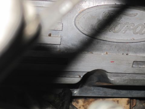 1989 Ford Bronco - Metal Ford engine part with the iconic Ford oval logo embossed on its surface.