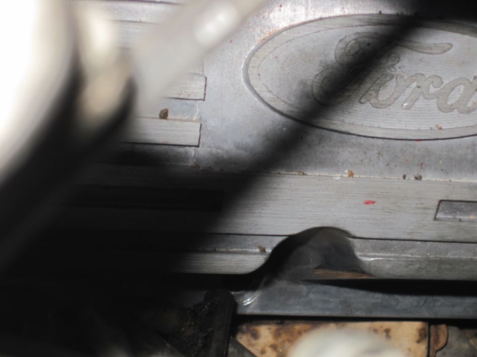 Close-up of a metal Ford engine component with the Ford oval logo visible