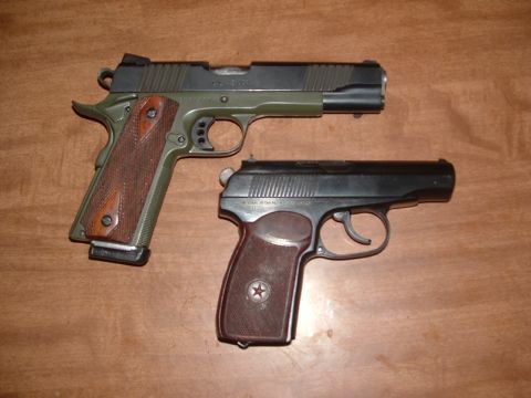 1990 Ford Bronco - Two handguns are displayed on a wooden table.