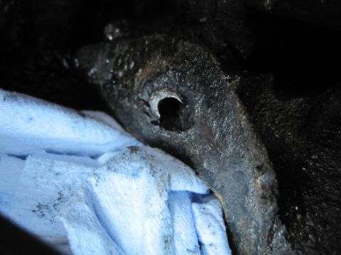 1989 Ford Bronco - A close-up view of a greasy engine component, partially covered by a blue cloth, likely during reassembly.