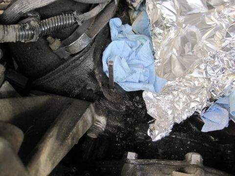 1989 Ford Bronco - A close-up view of an engine bay shows a dipstick, shop towels, and foil, suggesting maintenance work is in progress.