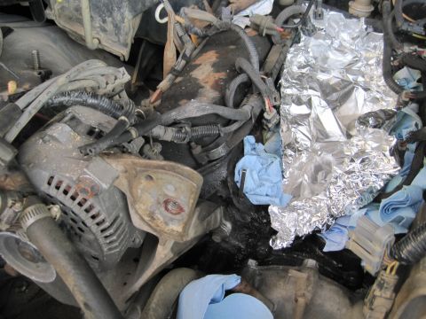 1989 Ford Bronco - Close-up view of a cluttered engine compartment with various parts and tools.