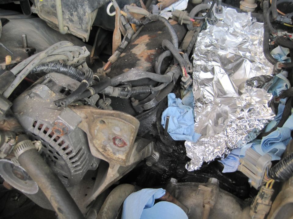 Engine compartment with alternator, wiring, and aluminum foil