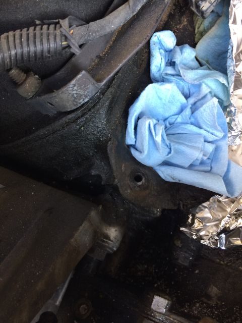1989 Ford Bronco - Close-up view of an engine bay, showing mechanical components and cleaning supplies.