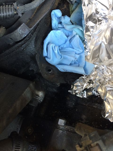 1989 Ford Bronco - Engine bay components are partially covered with blue shop towels and aluminum foil.