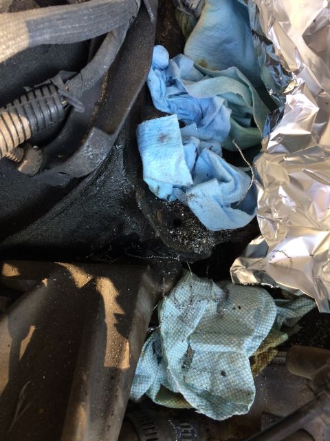 1989 Ford Bronco - Close-up view of engine parts, rags, and aluminum foil, suggesting a reassembly or maintenance process.