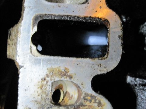 1989 Ford Bronco - This is a close-up view of a dirty engine intake manifold port, showing signs of wear and tear.