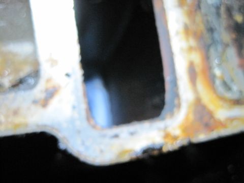 1989 Ford Bronco - A close-up view of a heavily corroded engine intake manifold, showing signs of wear and tear.