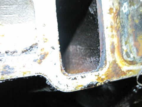 1989 Ford Bronco - Close-up view of an engine intake manifold, showing internal carbon deposits and wear.